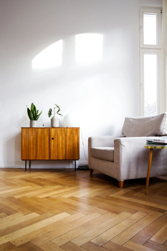 wooden floor room with brown wooden table beside gray couch